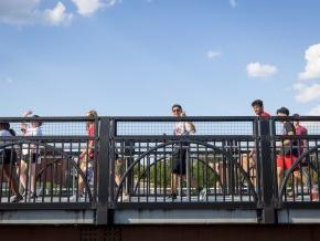 Students walk across a bridge on a sunny day